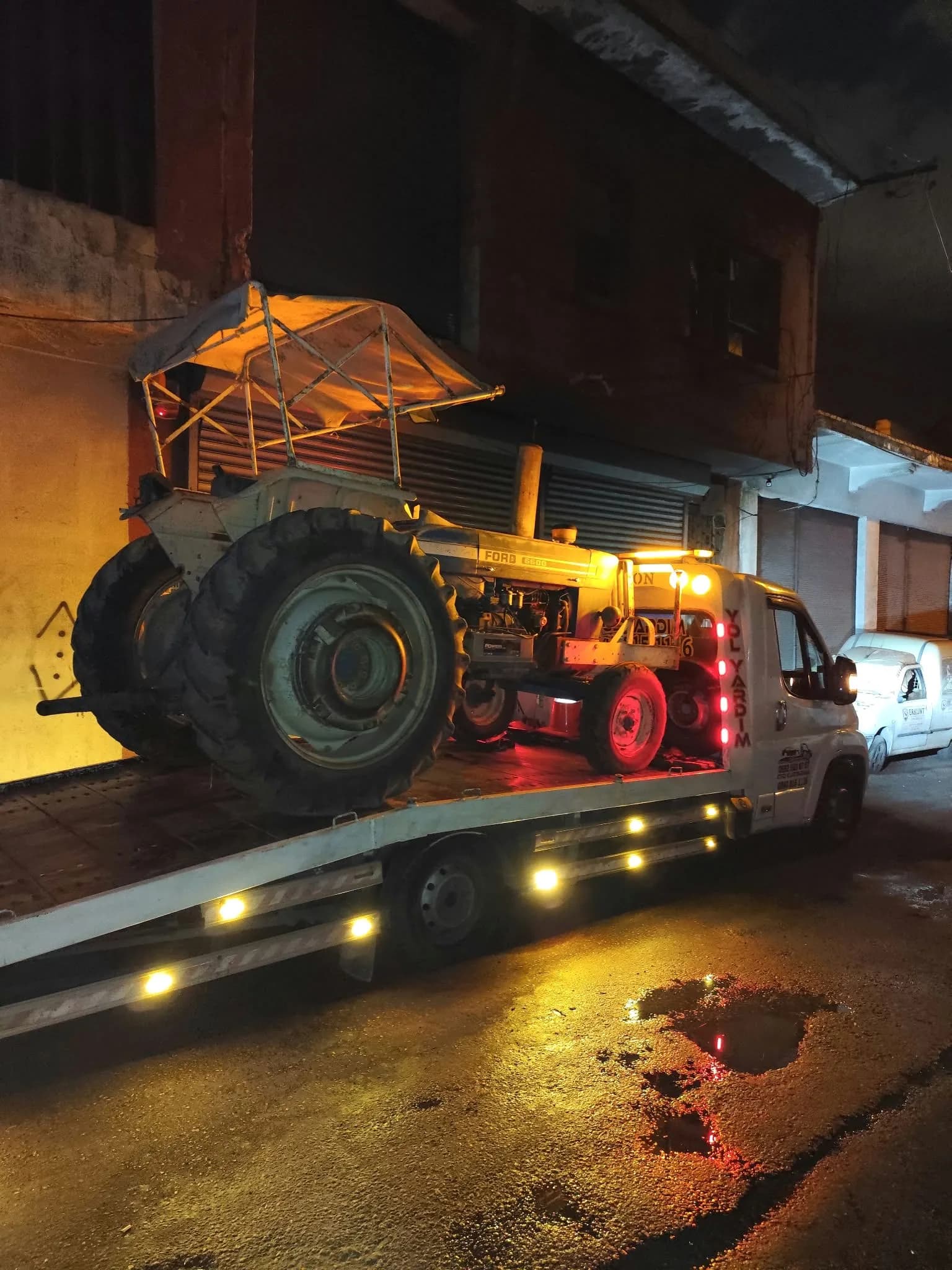Gece aydınlatmaları açık çekici üzerinde taşınan traktör