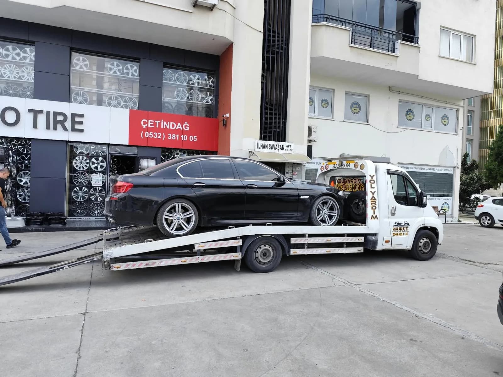 Özerler çekicisinin platformuna yüklenmiş siyah otomobil