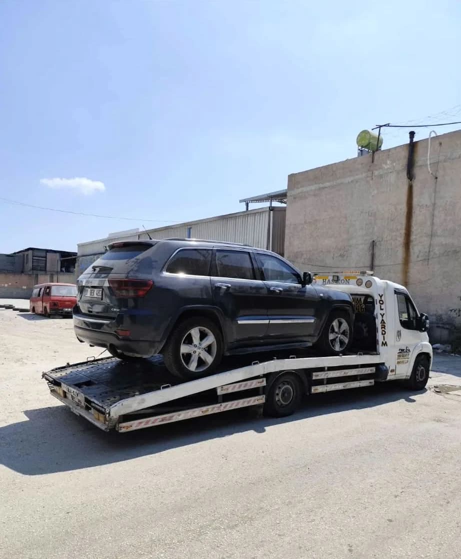 Gri SUV aracın platformlu çekiciyle taşınması